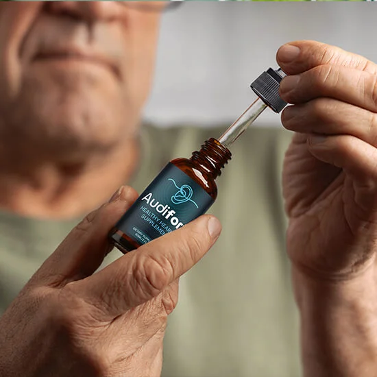 A person holding an Audifort bottle and dropper